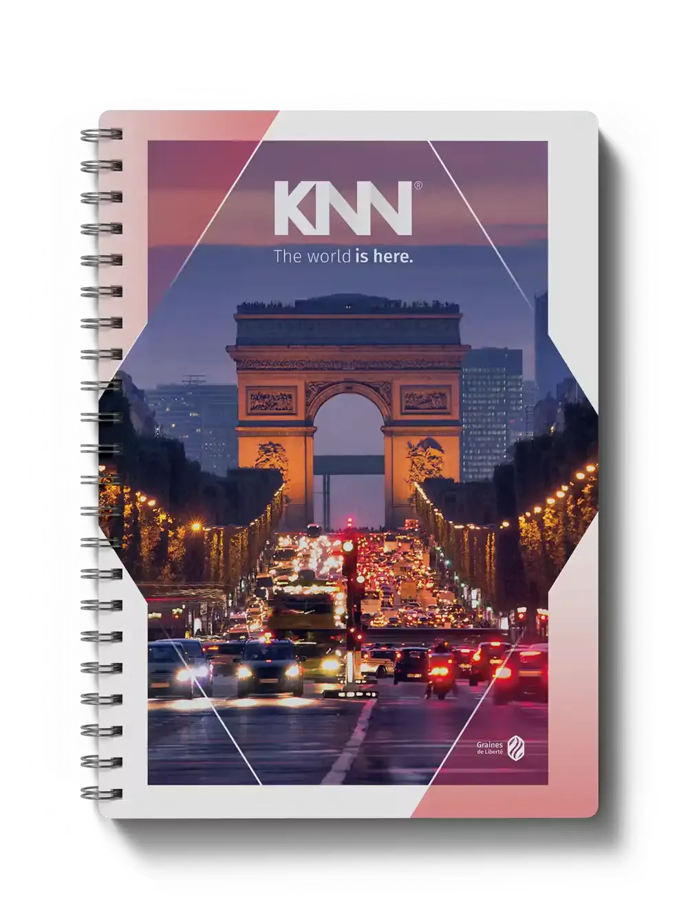 Capa de caderno com capa rígida em design geométrico com a marca KNN, frase “The world is here.” e foto do Arco do Triunfo em Paris ao entardecer, com trânsito iluminado.