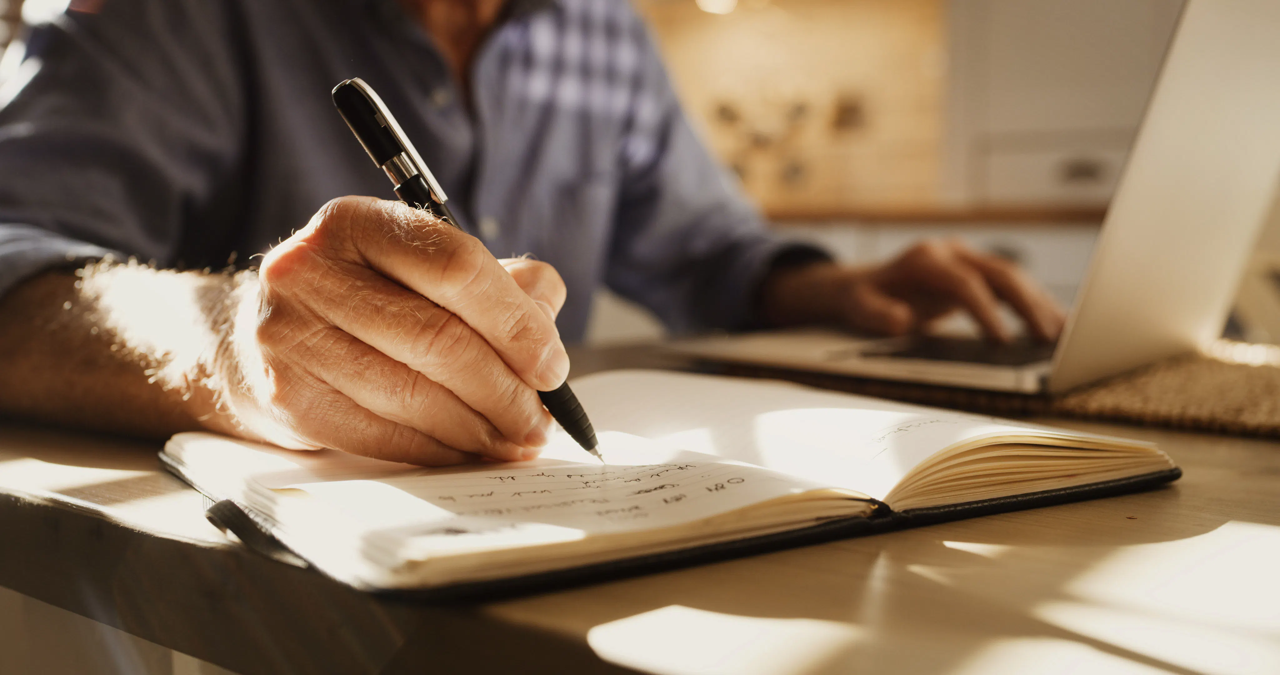 homem escrevendo em seu caderno 