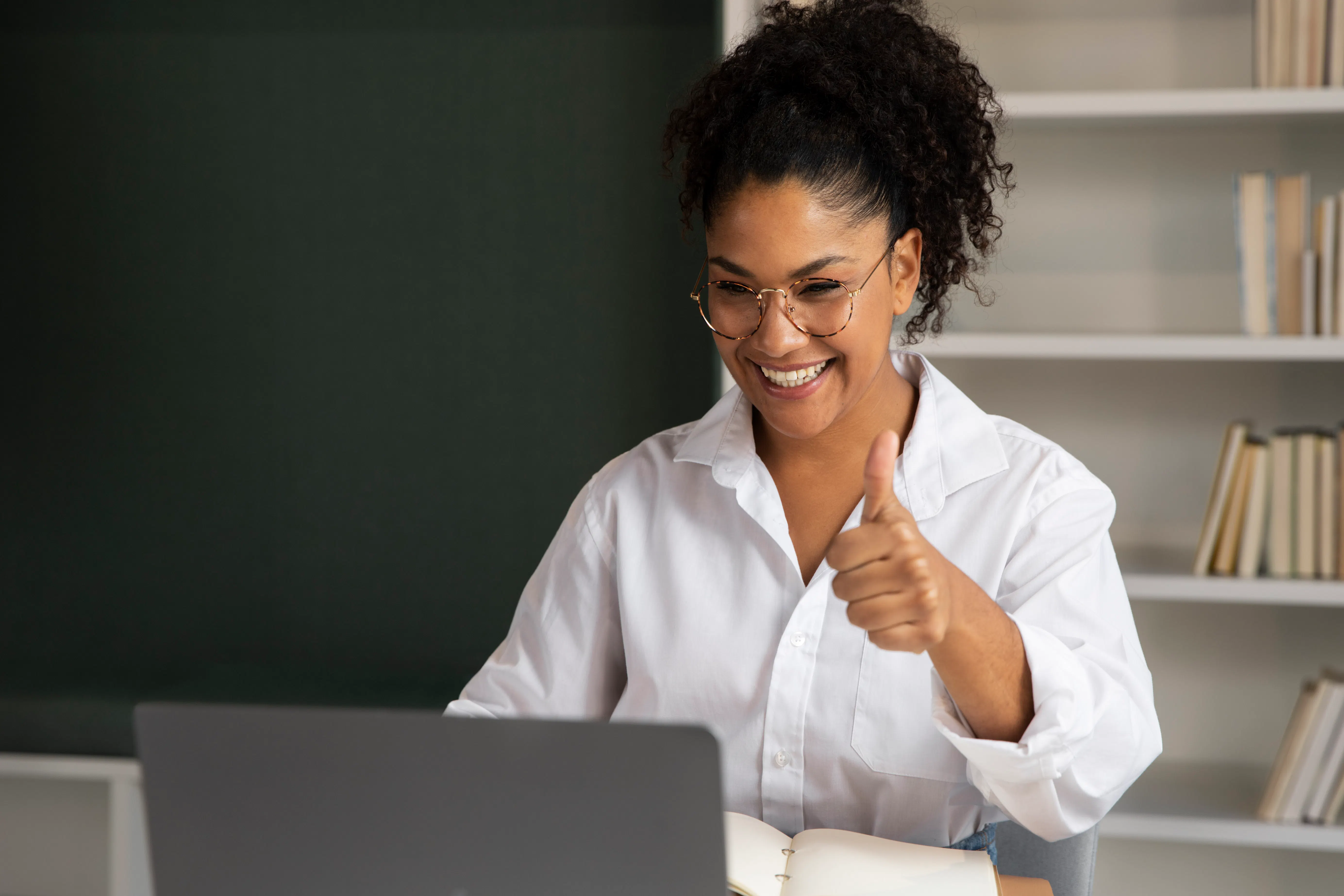 mulher em camiseta branca , assisti aula em seu notebook