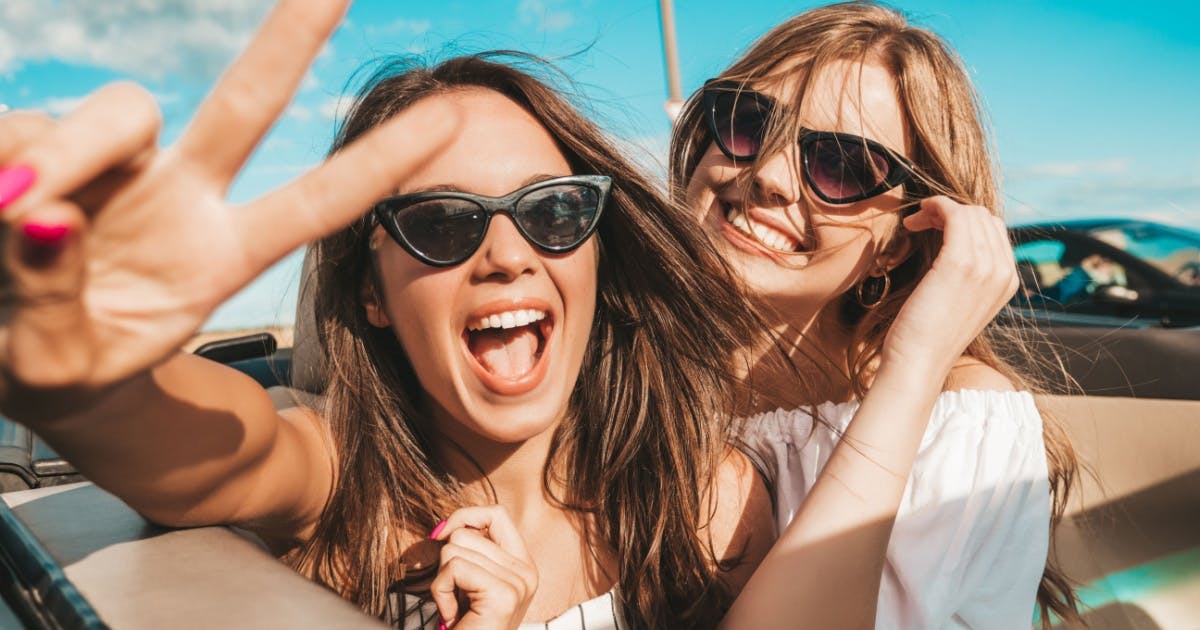 Duas mulheres felizes e sorrindo com óculos. 