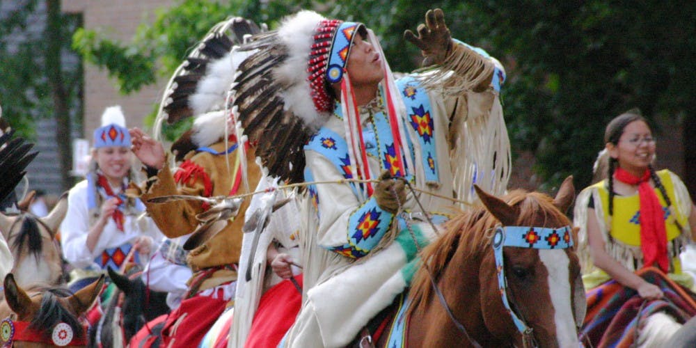 Pessoas com roupas típicas de nativos do Canadá