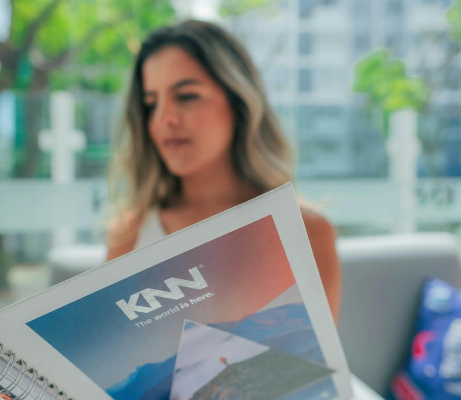 Mulher com o livro da KNN Idiomas na mão.