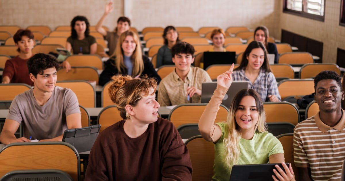 Alunos sorrindo e interagindo dentro de uma sala de aula, na visão do professor.