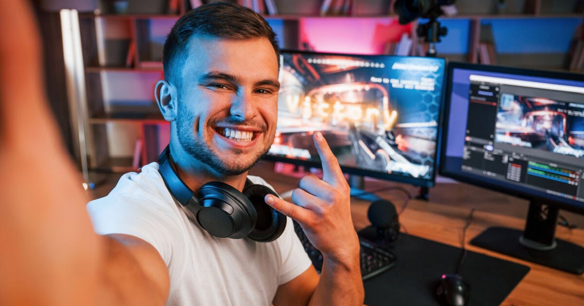 Homem sorrindo enquanto levanta um dedo, expressando alegria e positividade em sua atitude.