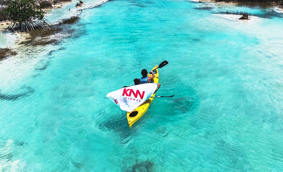 Caiaque em Tulum com uma bandeira da KNN Idiomas.