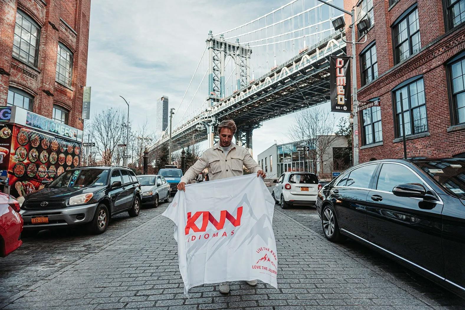Homem segurando a bandeira da KNN no meio da rua