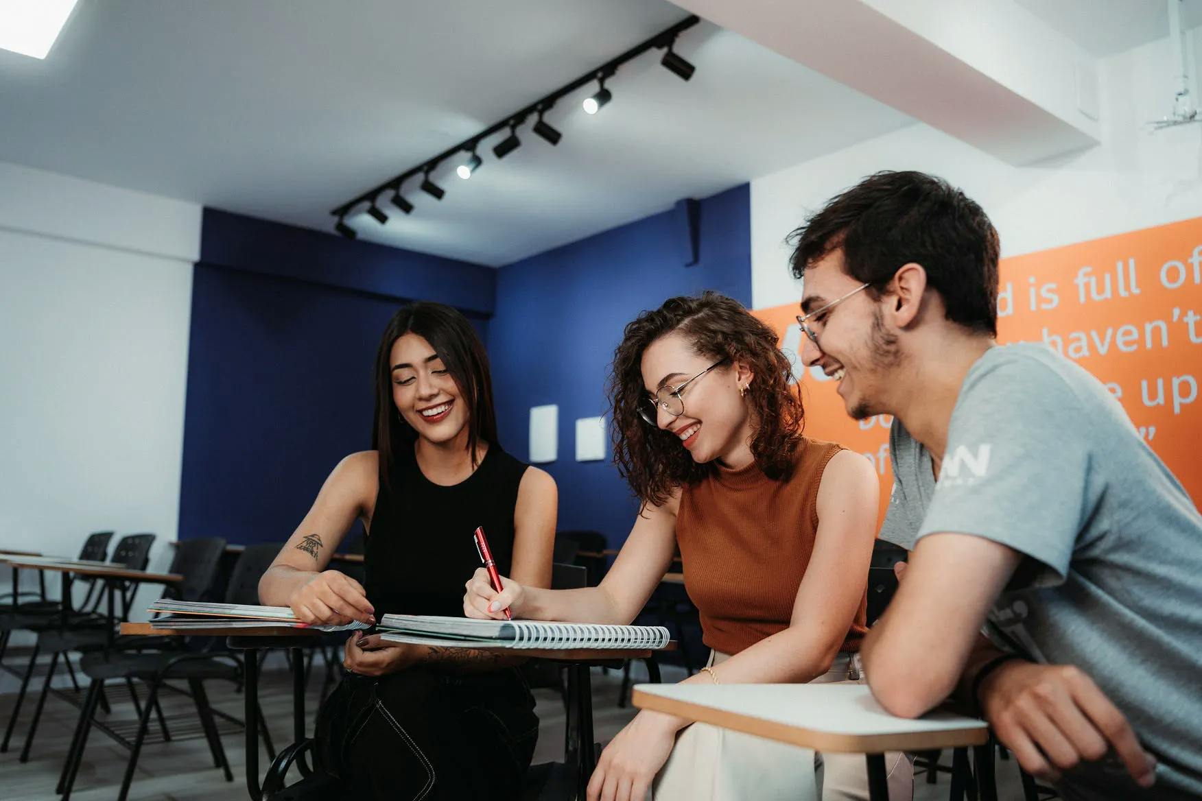 Três pessoas estudando em uma sala de aula
