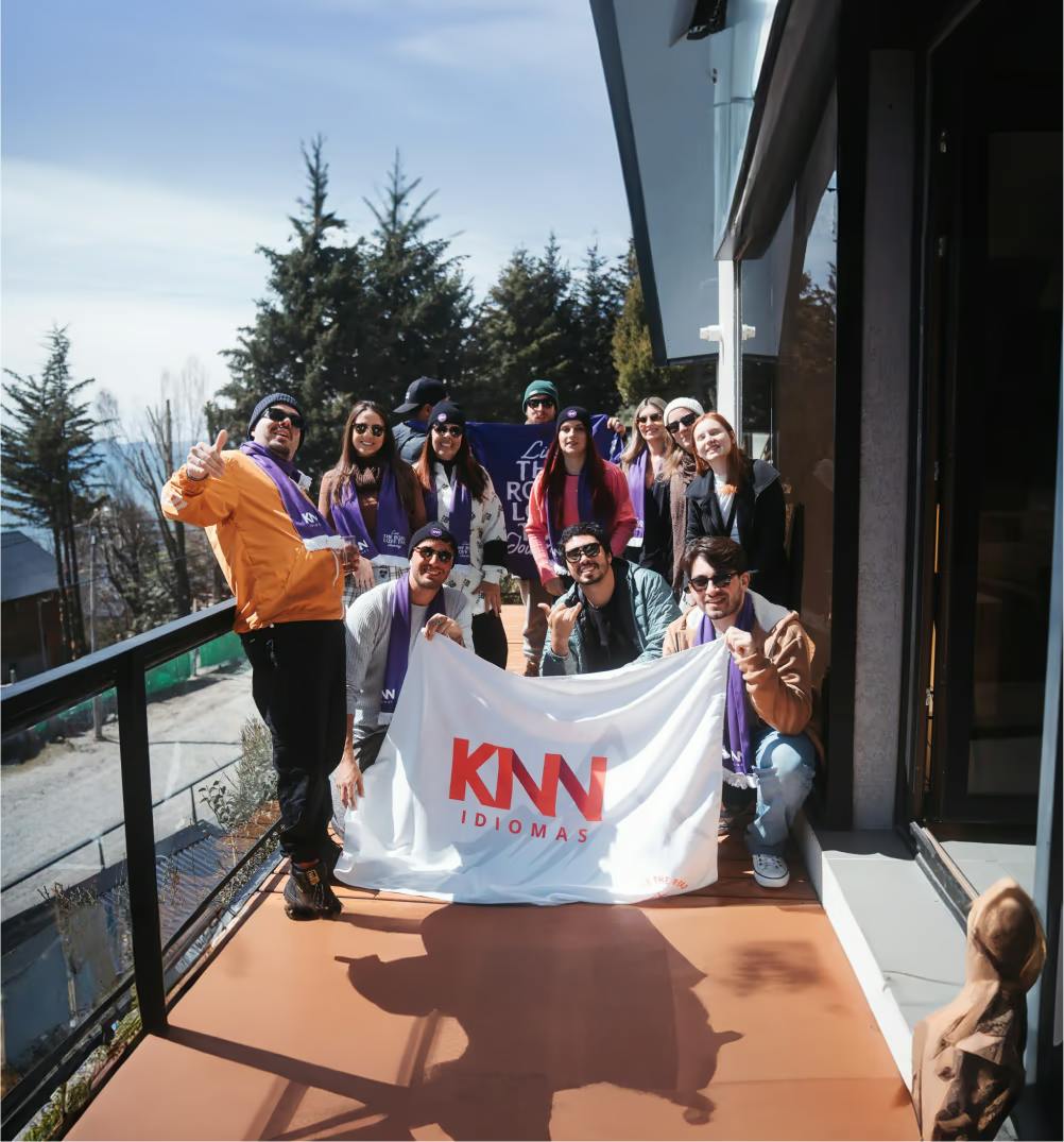Grupo de pessoas posando com a bandeira da KNN