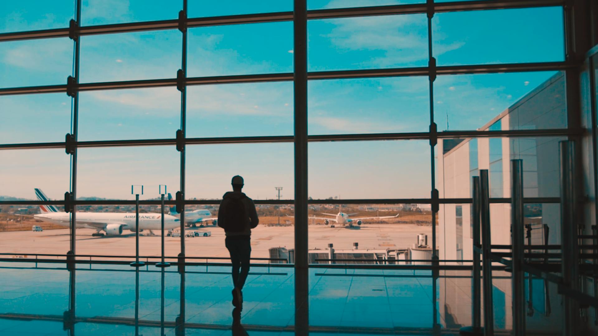 imagem silhueta de um homem em frente à janela do aeroporto