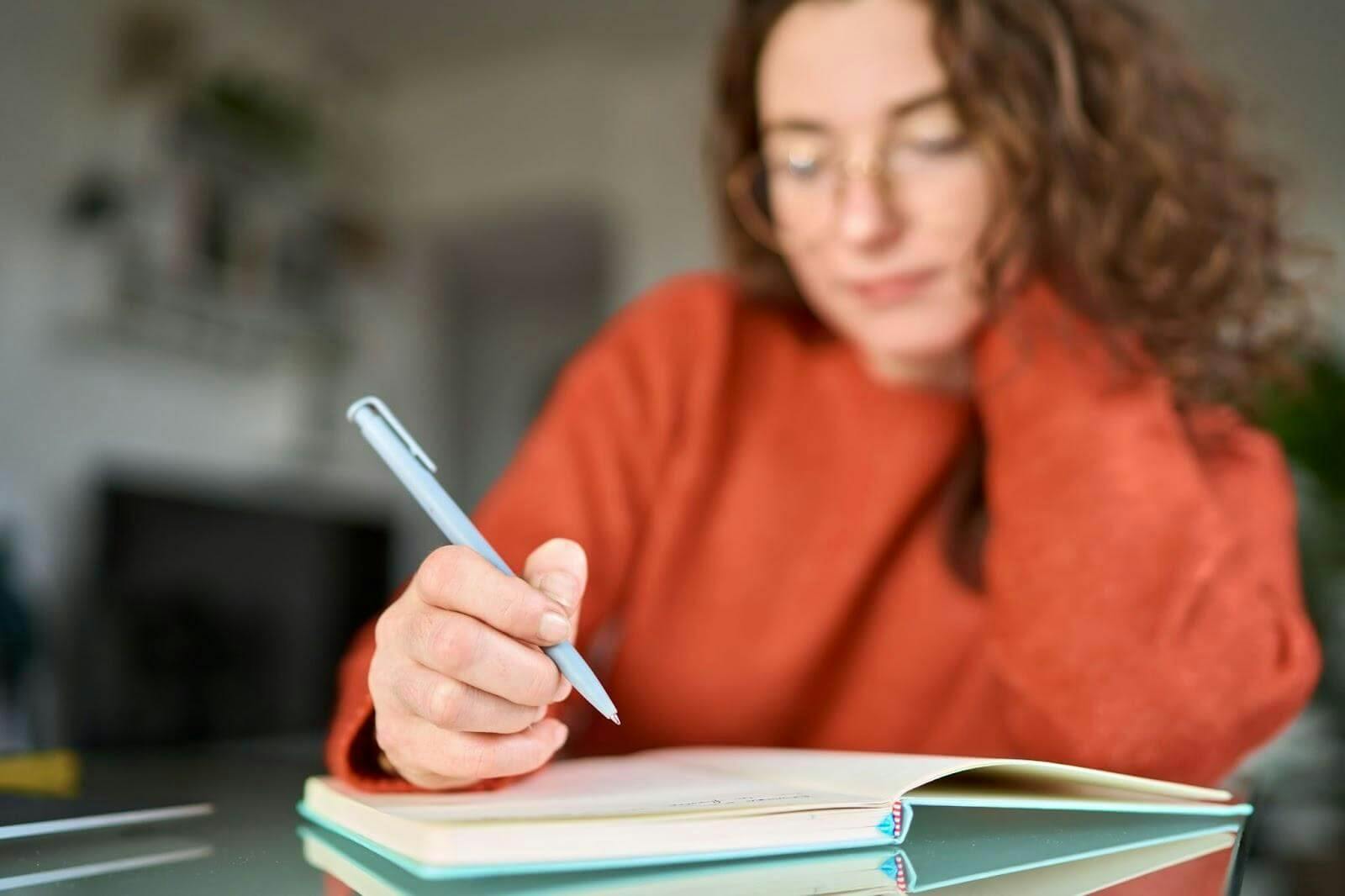 Mulher escrevendo em um caderno