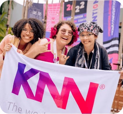 3 mulheres segurando a bandeira da KNN