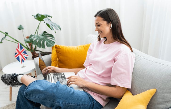 Mulher sentada no sofá usando o computador