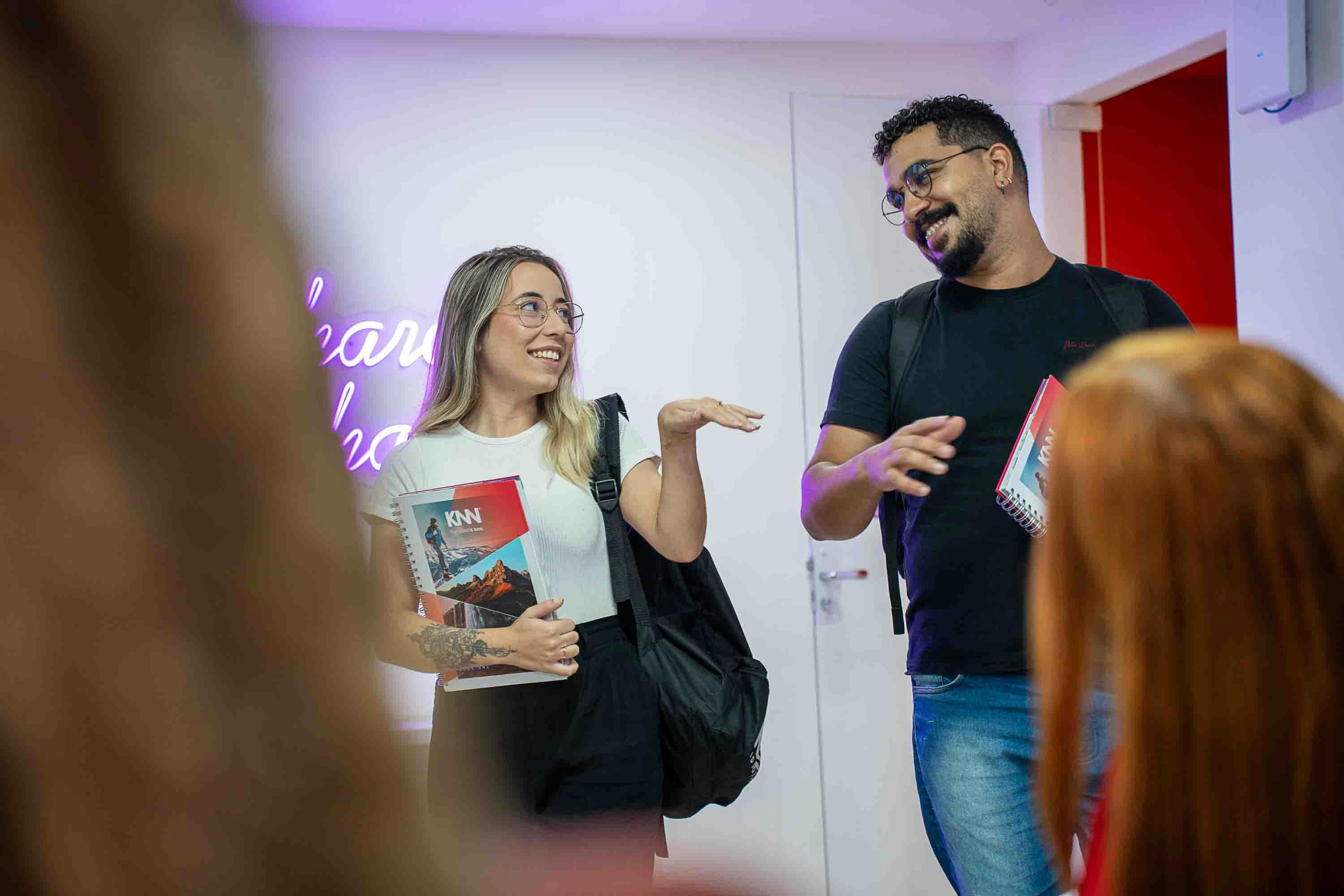 alunos sorrindo segurando livros didaticos