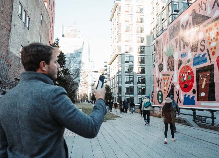 Homem tirando foto de um mural