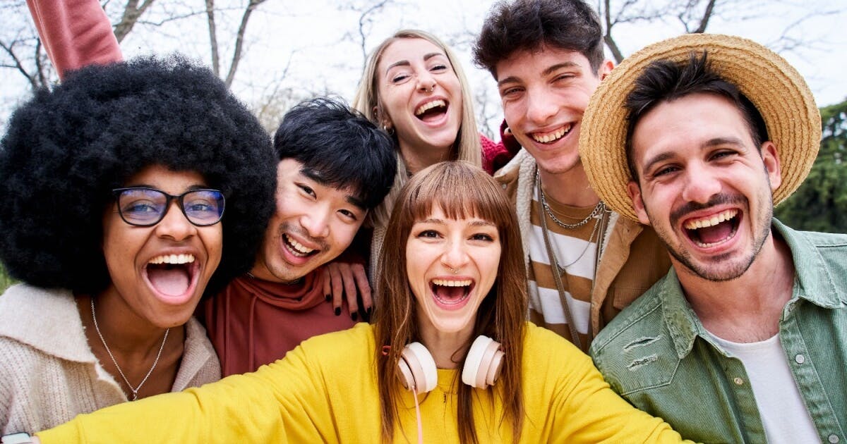 Grupo de jovens sorrindo e rindo, transmitindo alegria e descontração em um ambiente amistoso e acolhedor.