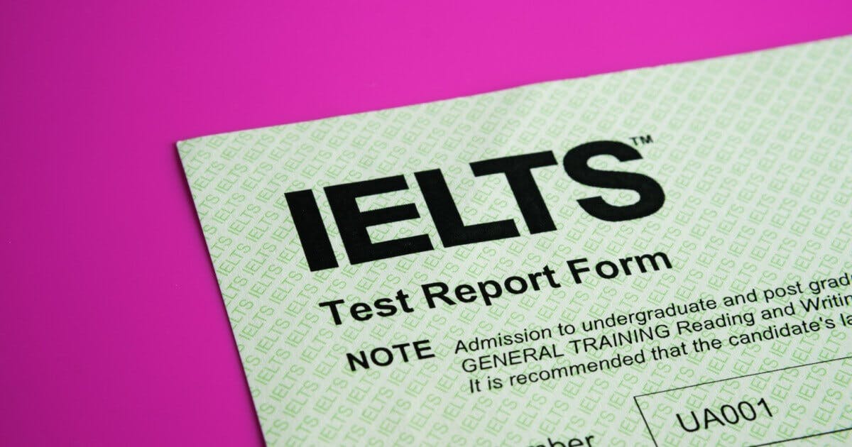 Uma folha escrito IELTS abaixo de um plano rosa.