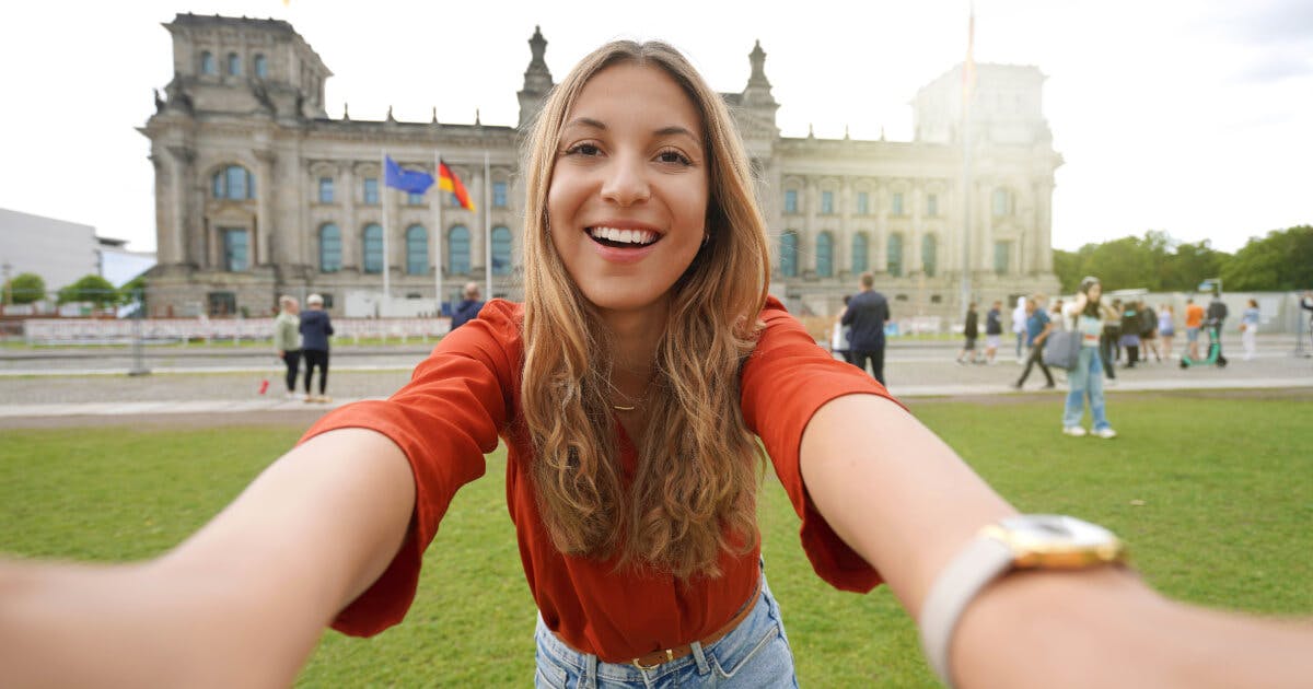 Uma mulher tirando uma selfie em frente a um edifício.