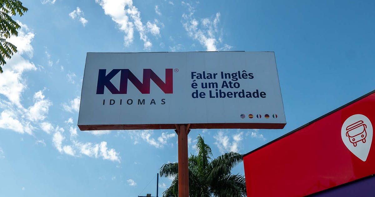 Outdoor da KNN Idiomas com logo da marca e o lettering "Falar Inglês é um Ato de Liberdade."