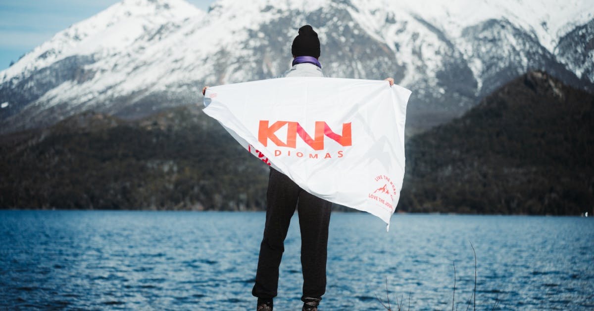 Homem de touca de costas e com a bandeira da KNN Idiomas.