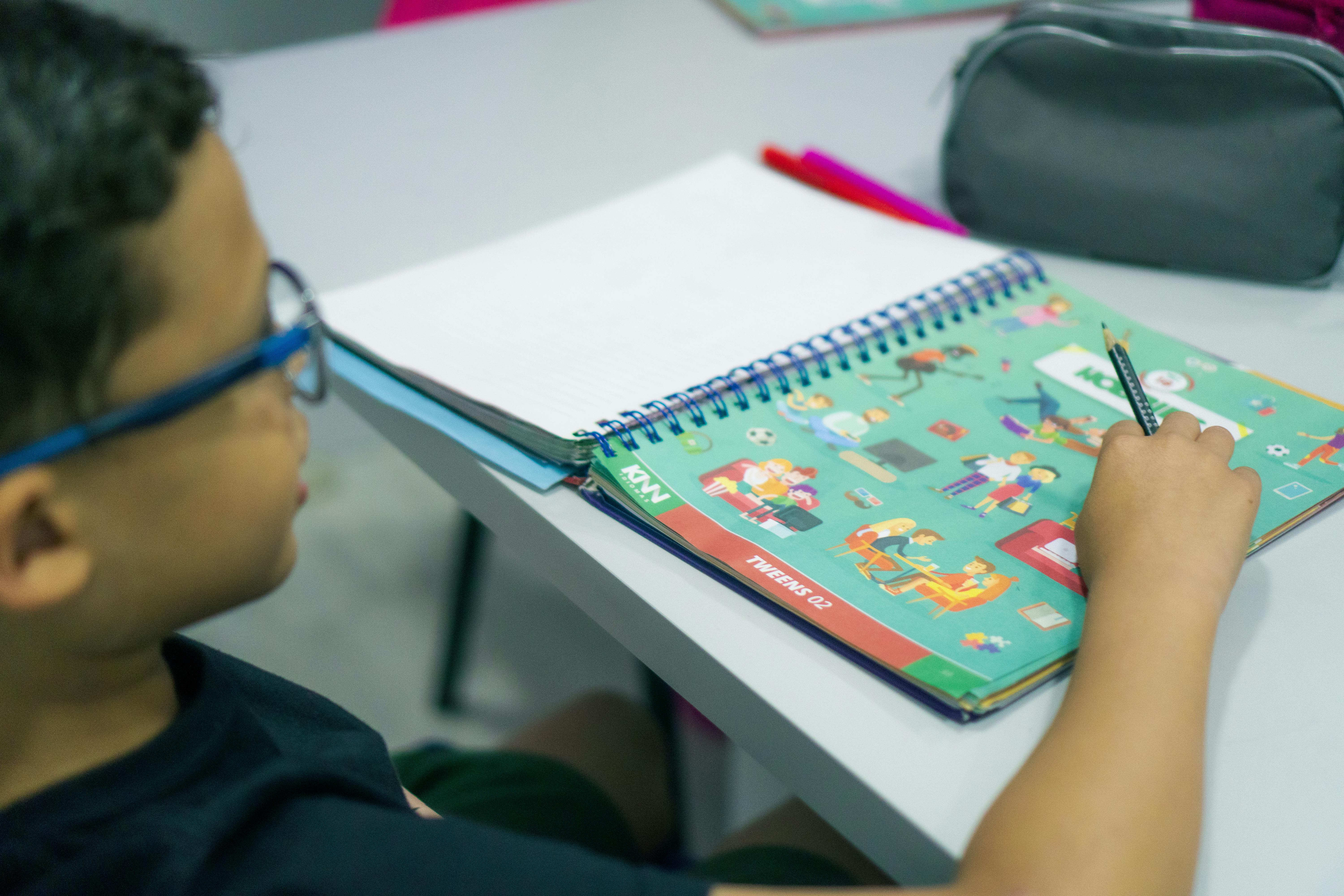 Criança escrevendo em um caderno.