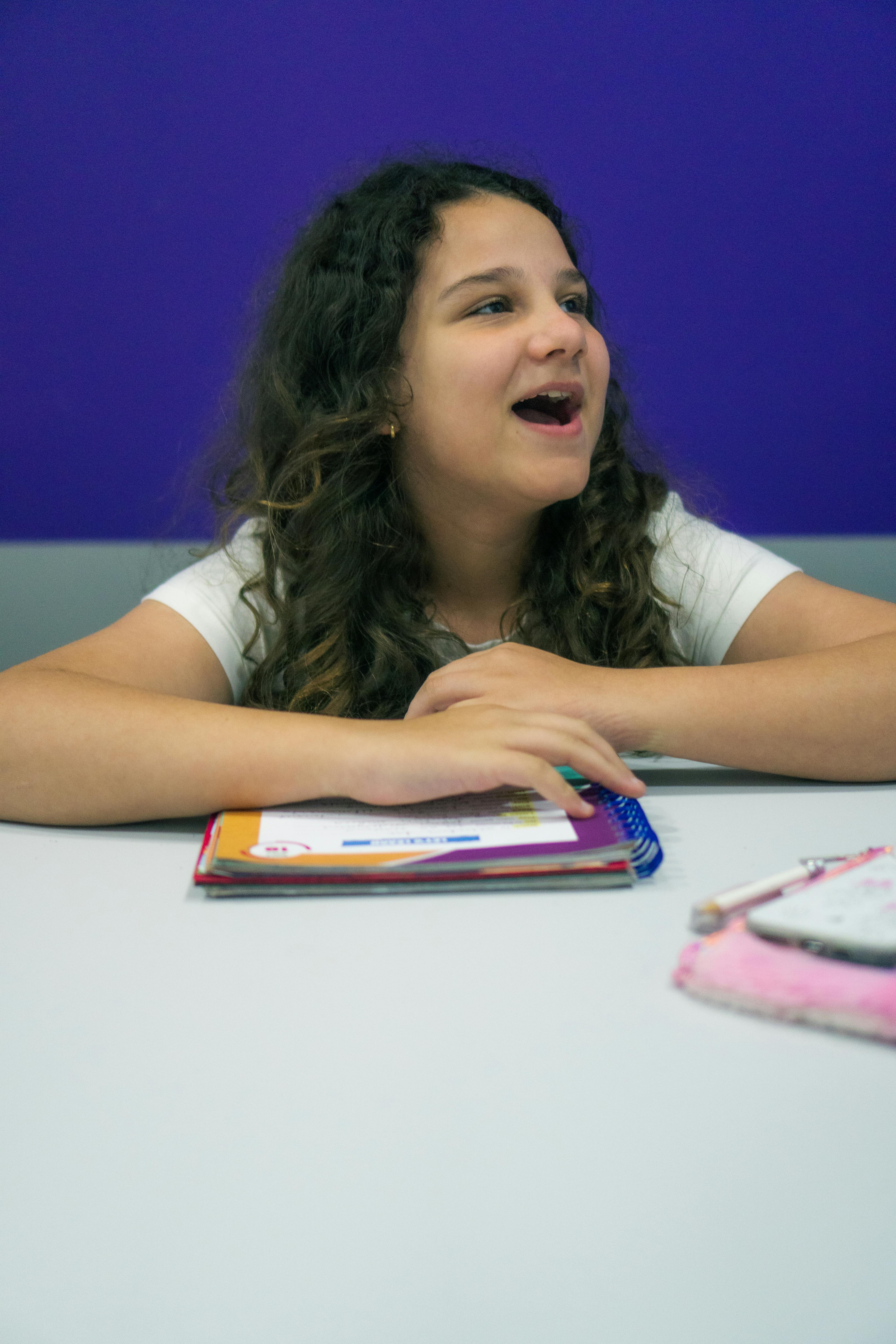Criança sorrindo em uma sala de aula.