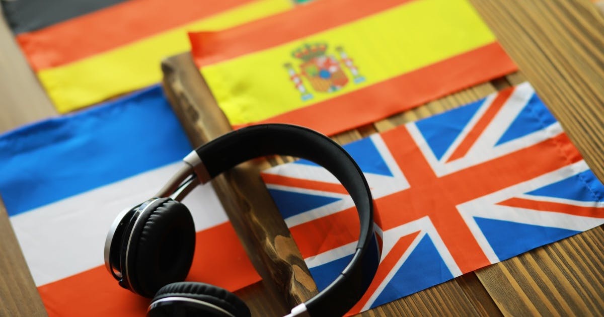 Fotos de bandeiras de países da França, Espanha, Alemanha e Reino Unido e, em cima delas, um fone de ouvido.