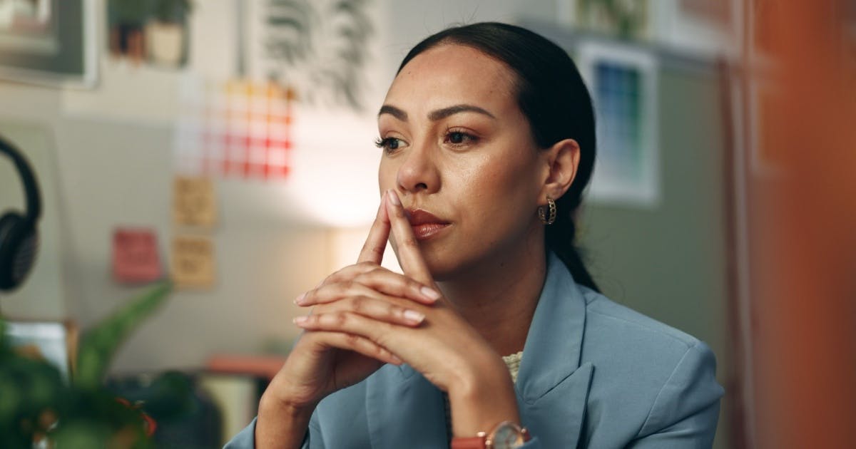 Mulher as mãos na boca e expressão de dúvida.