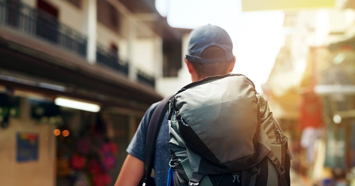 Homem de boné e mochila nas costas.