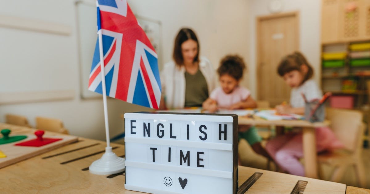 Professora orientando duas alunas em sala de aula.