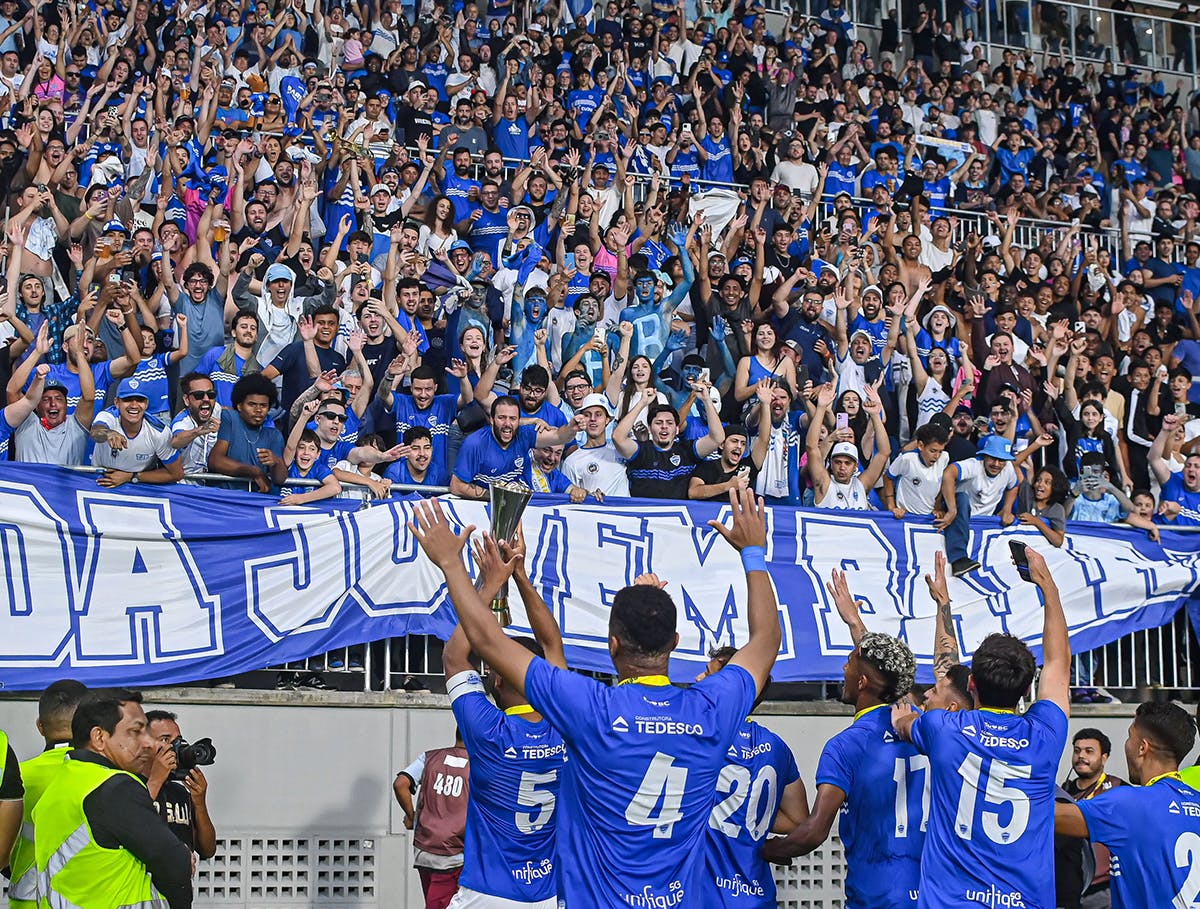 Foto dos jogadores do Barra Futebol Clube comemorando com a torcida na Arena Barra FC.