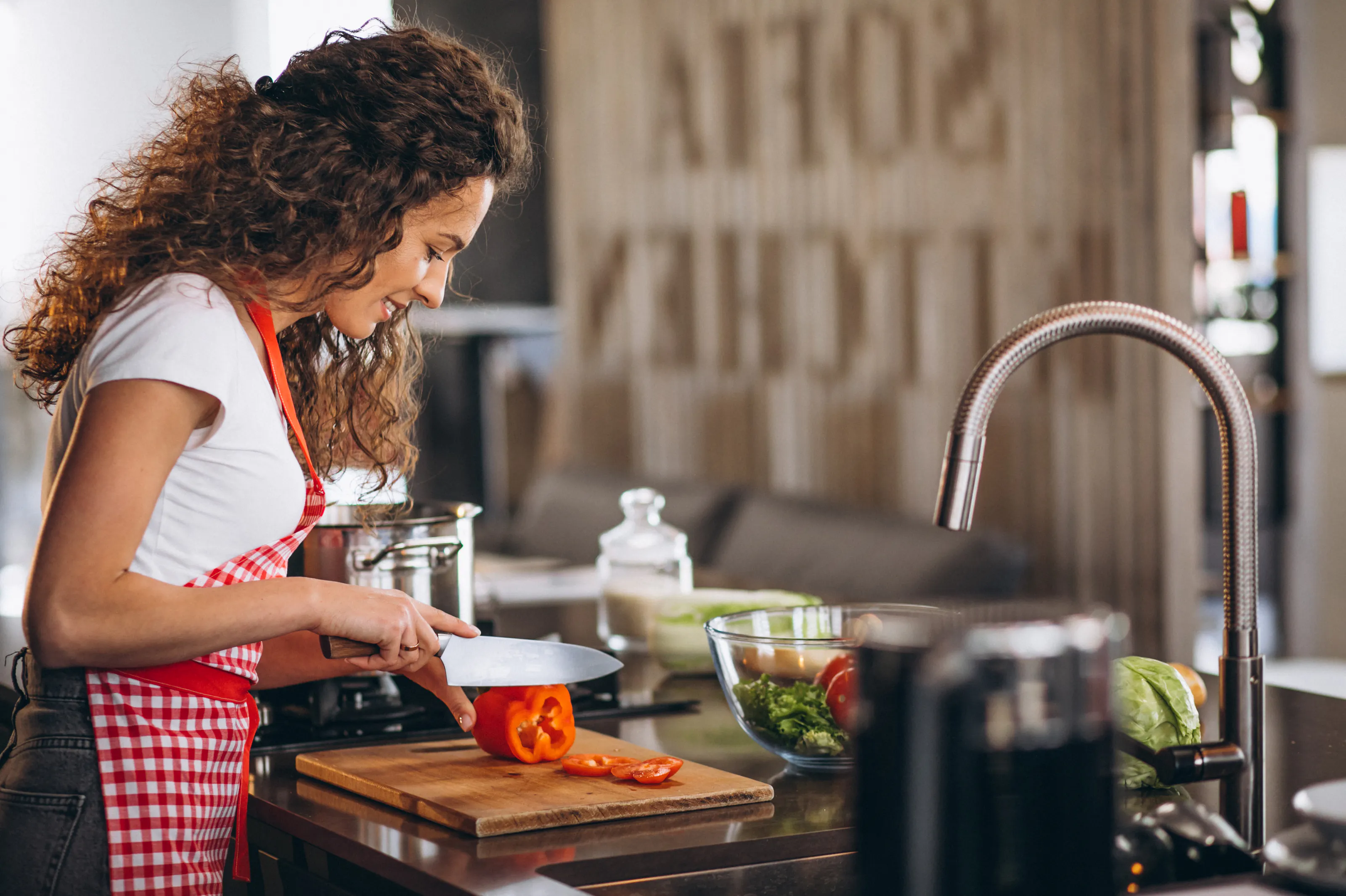 uma mulher jovem na cozinha, cozinhando