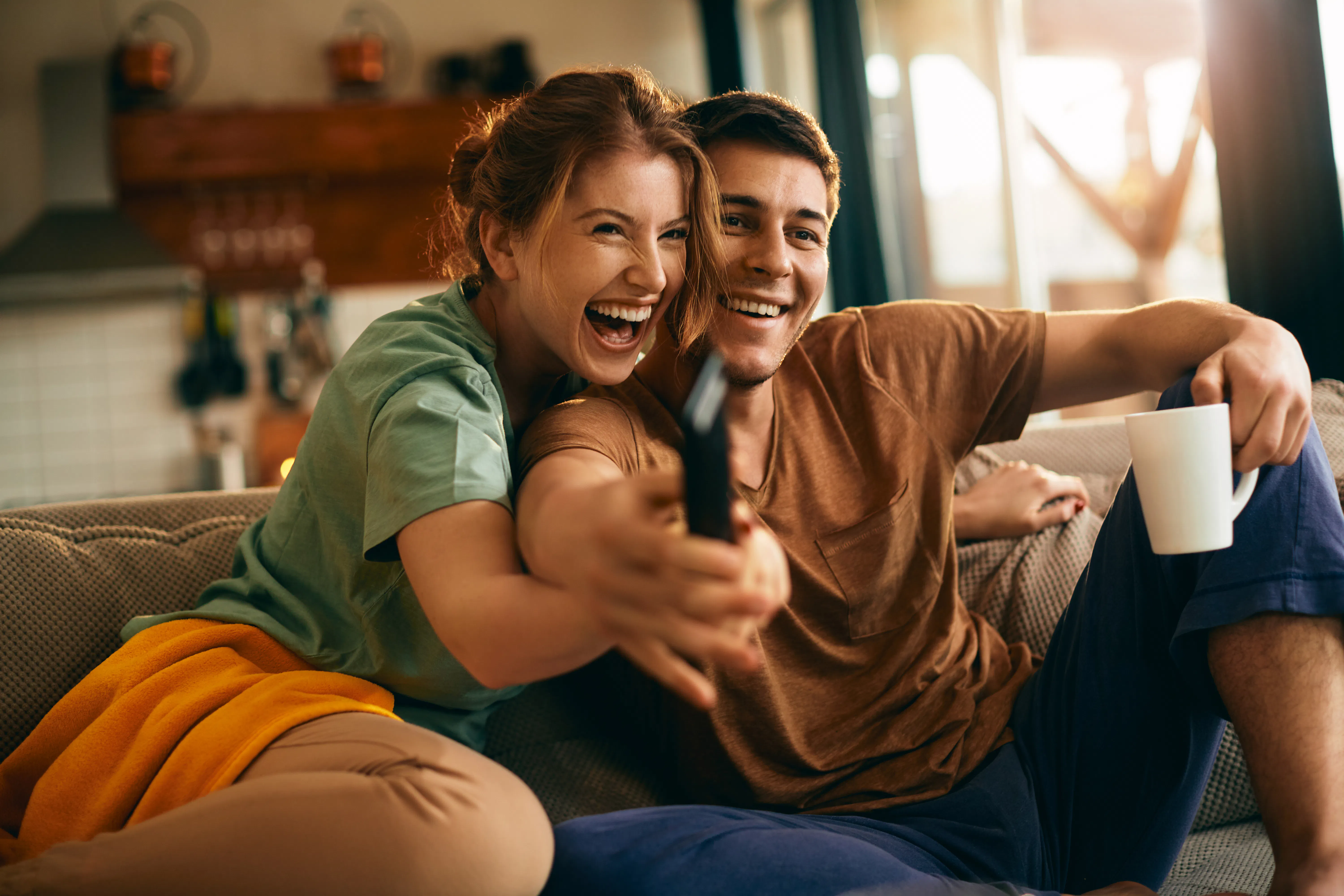 casal assistindo TV, sorrindo