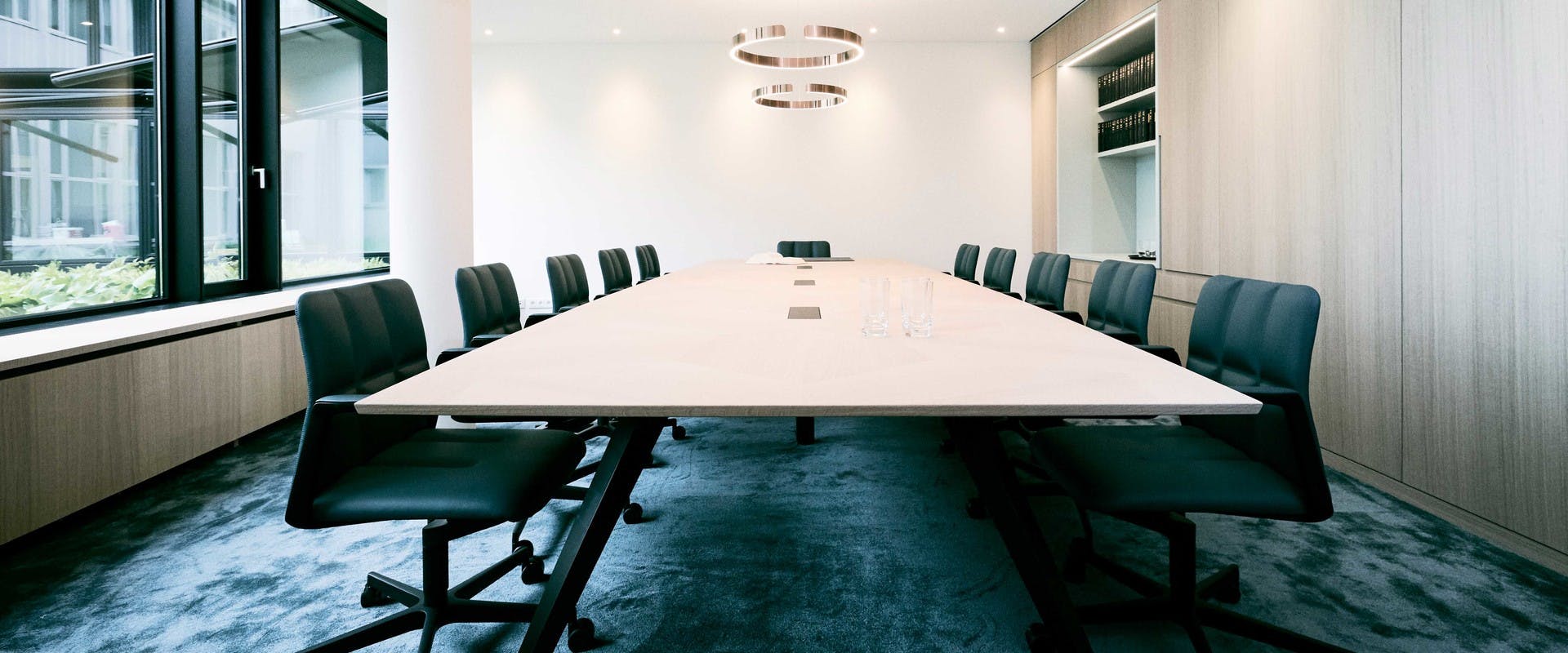 Bild zeigt einen großzügigen Konferenztisch in einem modernen Raum