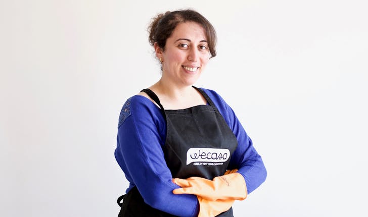 Wecasa  professional housekeeper crosses her arms and smiles as she wears orange cleaning gloves 