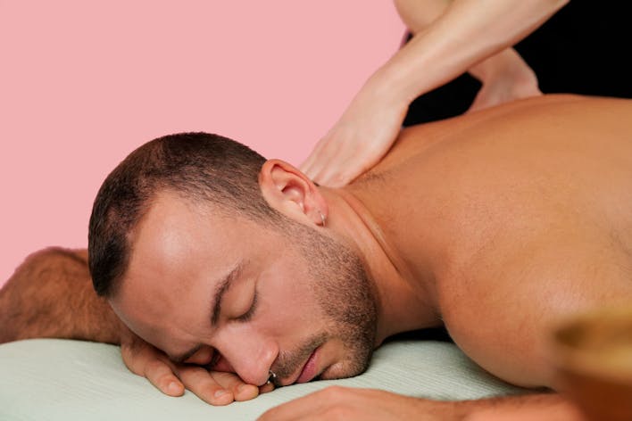Homme se faisant masser le dos par un masseur professionnel à domicile