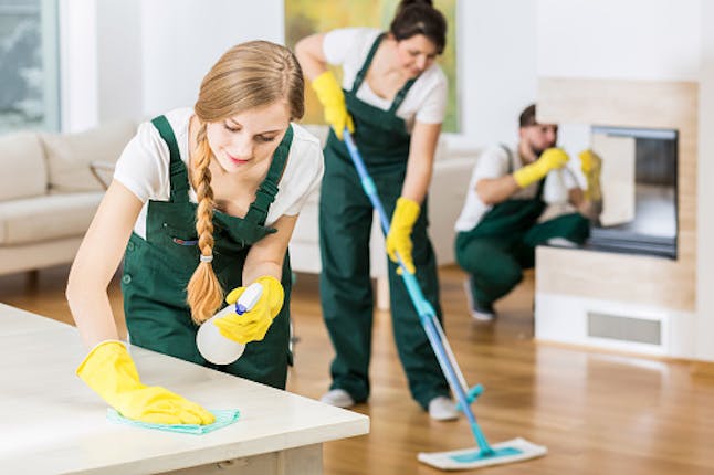 professional cleaning ladies in yellow aprons cleaning a flat 