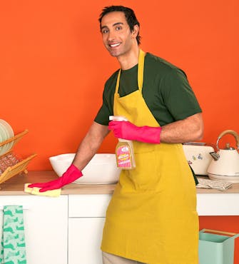 Homme de ménage qui nettoie la cuisine