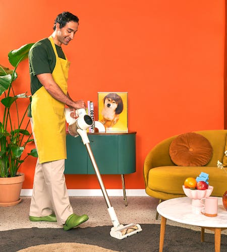A housekeeper vacuuming the floor