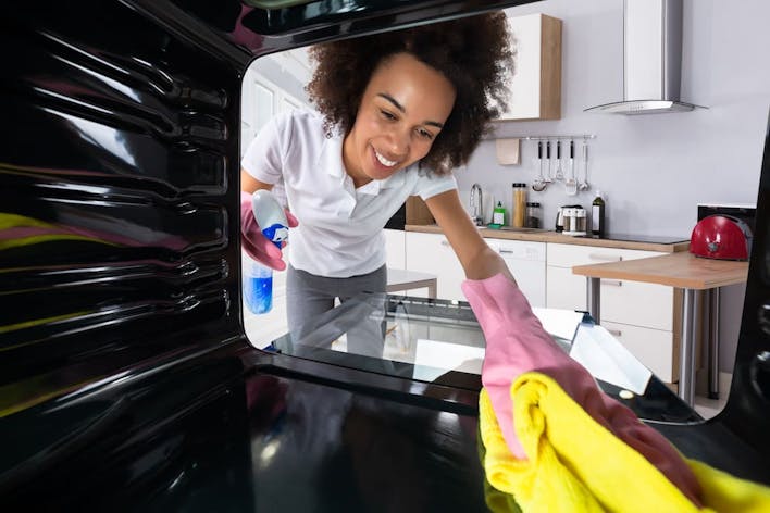 Domestic cleaner cleaning inside of oven
