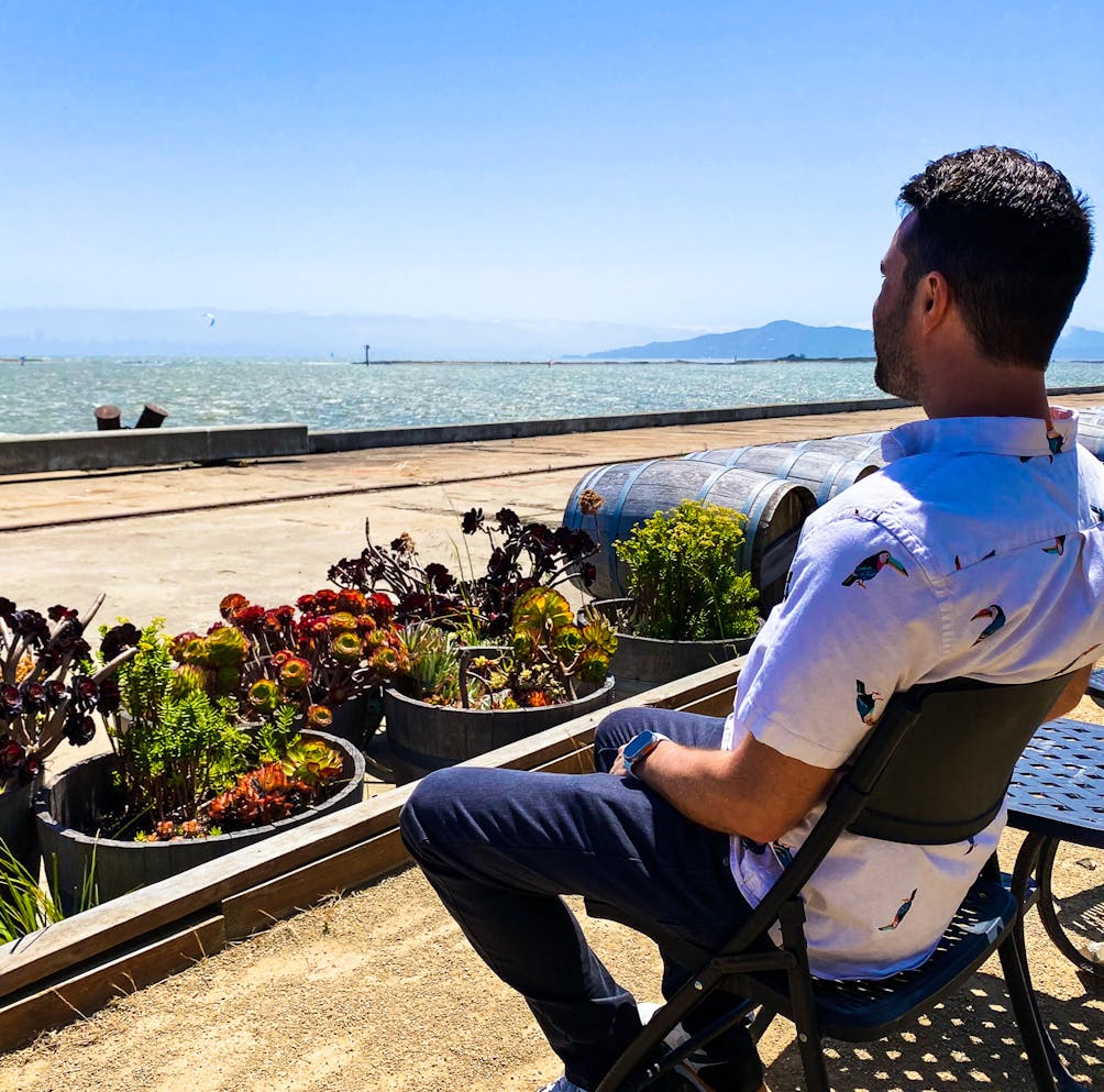 Person sitting on the outdoor patio overlooking that Bay at Riggers Loft in the historic Richmond Shipyard