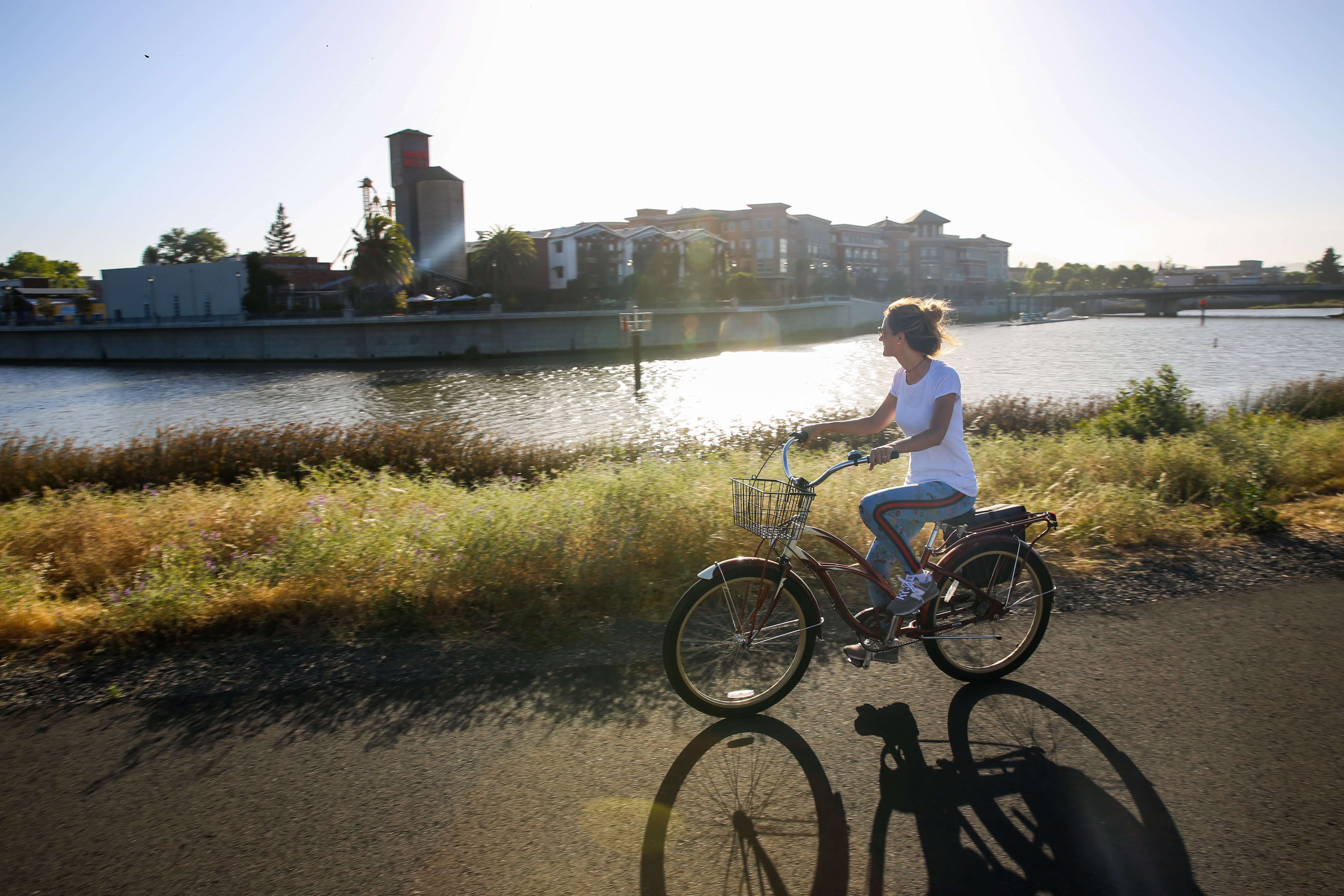 Person cycling by river 