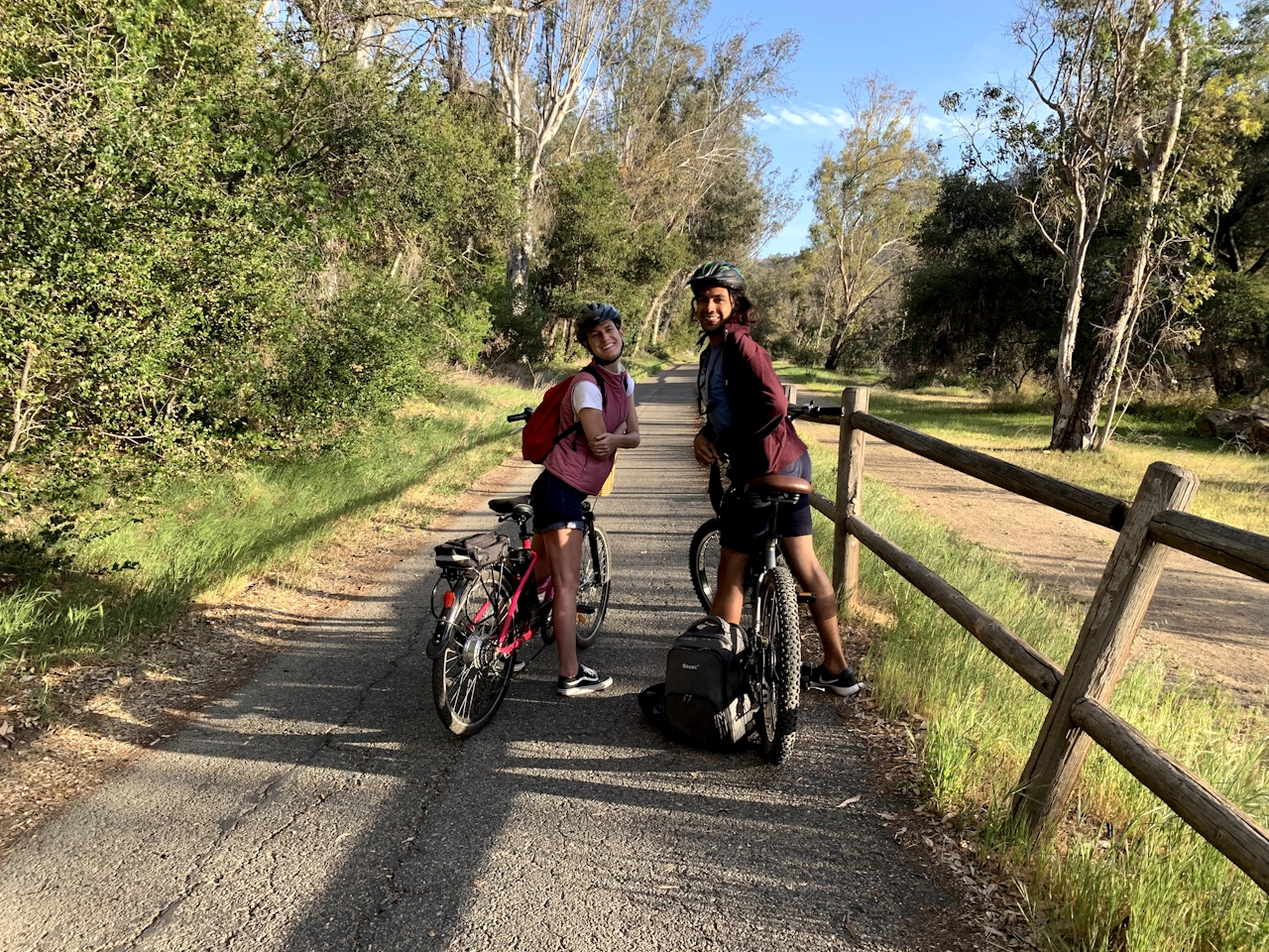 A couple on their bikes looking back to the camera smiling on the Ventura to Ojai bike path.