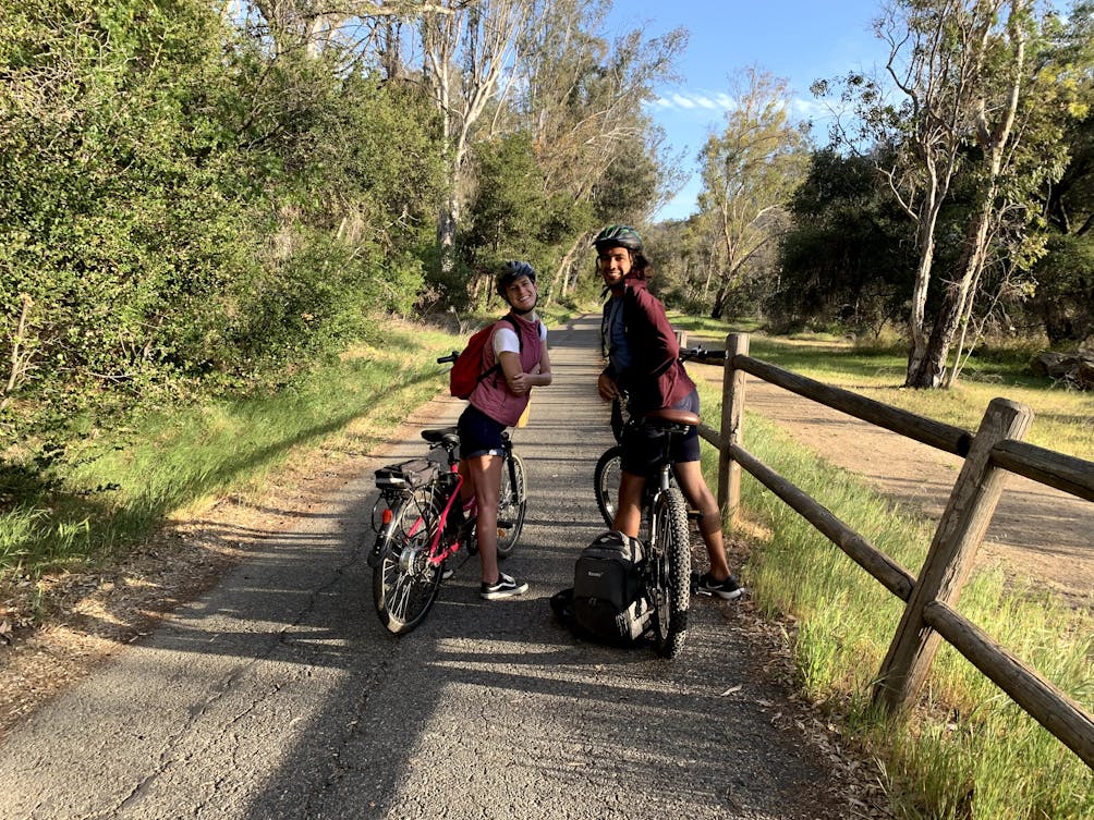 A couple on their bikes looking back to the camera smiling on the Ventura to Ojai bike path.