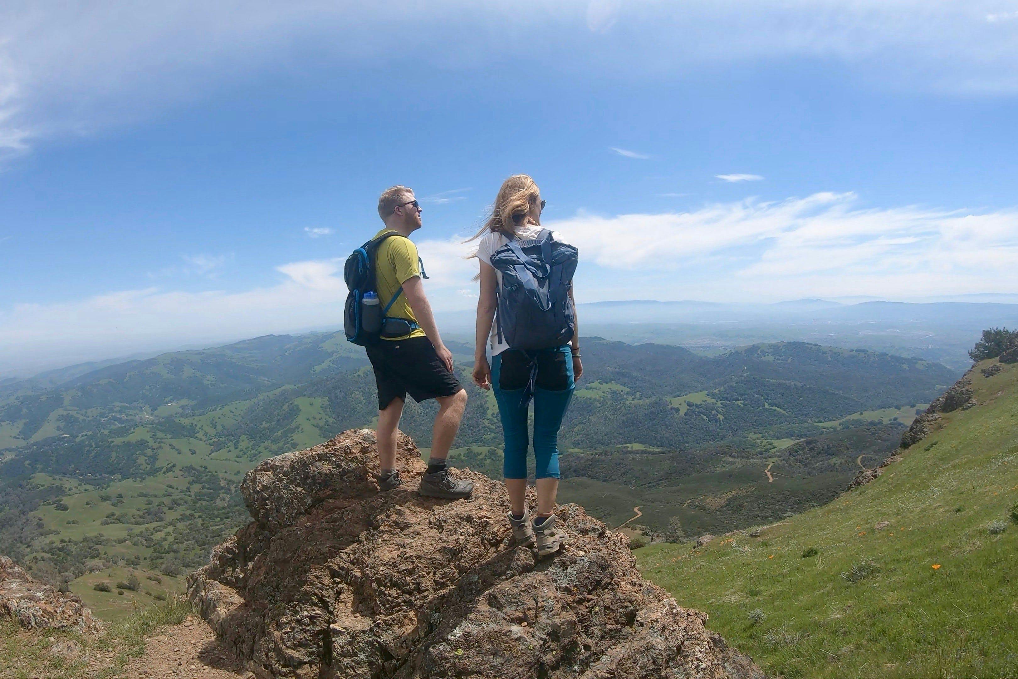 Two hikers stand on top of Mount Diablo