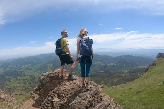 Two hikers stand on top of Mount Diablo