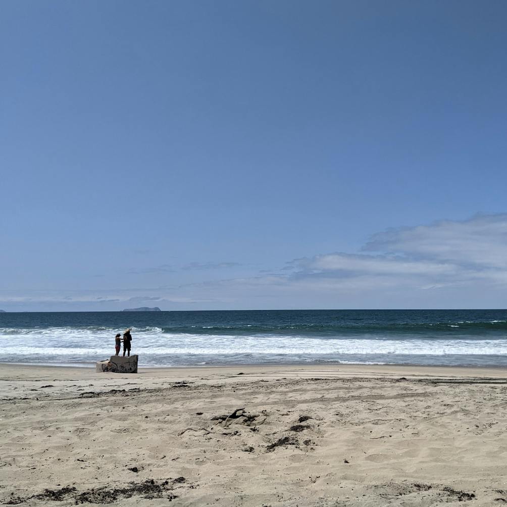 A couple stand on a concreted structure on the beach at Border Field State Park in San Diego County 