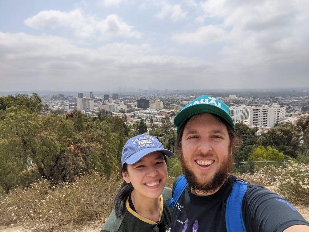 Selfie of couple on a hike at a Runyon Canyon overlook in Los Angeles overlooking the city 