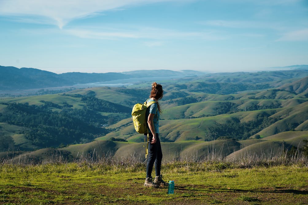 Woman standing at the top of Barnabe Peak, looking out to Tomales Point and Bodega Bay 
