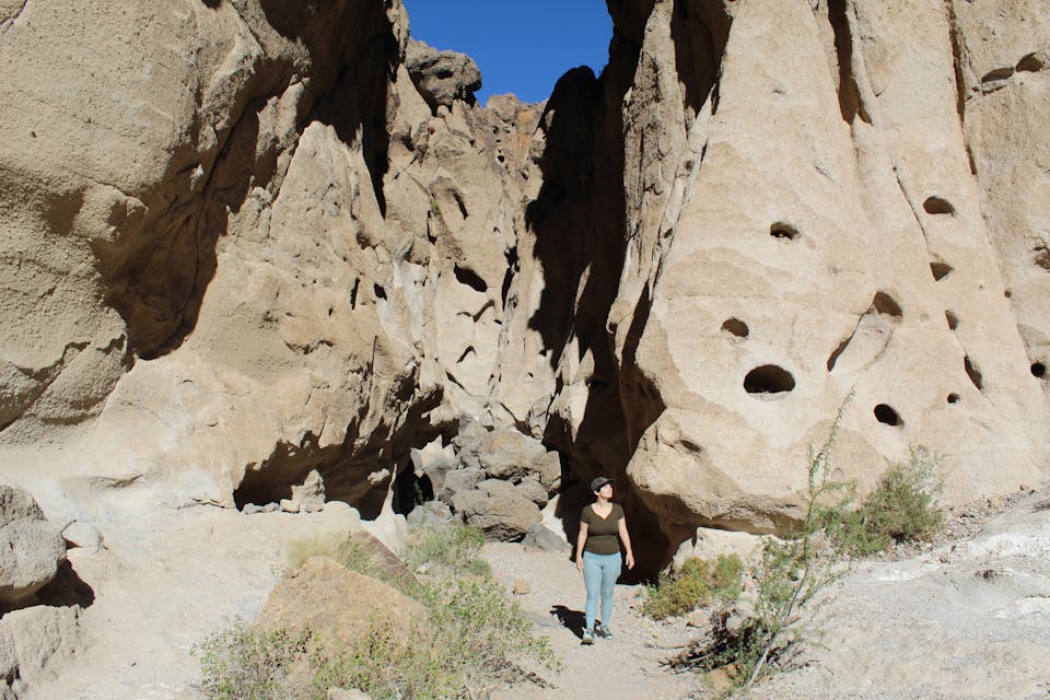 Hiker coming out of a canyon at Hole in the Wall Rings Loop Trail Mojave Desert 
