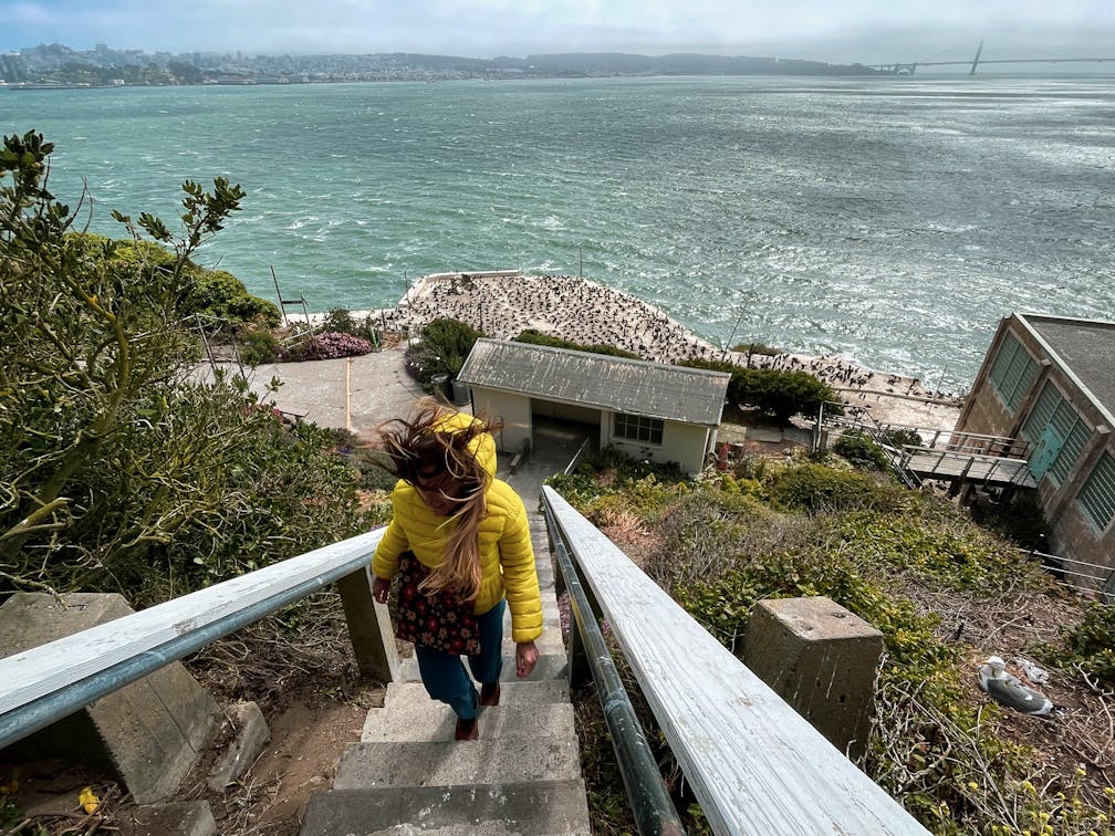 Woman walking up stairs overlooking the Pacific Ocean from Alcatraz Island 